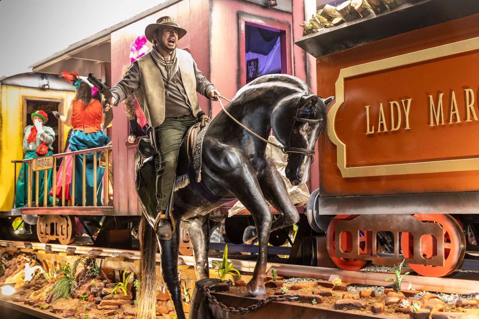 A character in a cowboy costume riding a 'horse' on a Westerns-themed float at the Weston-super-Mare Carnival